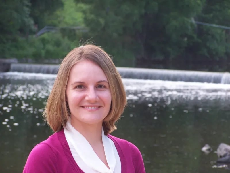 Stephanie Tobey smiling outdoors near a waterfall